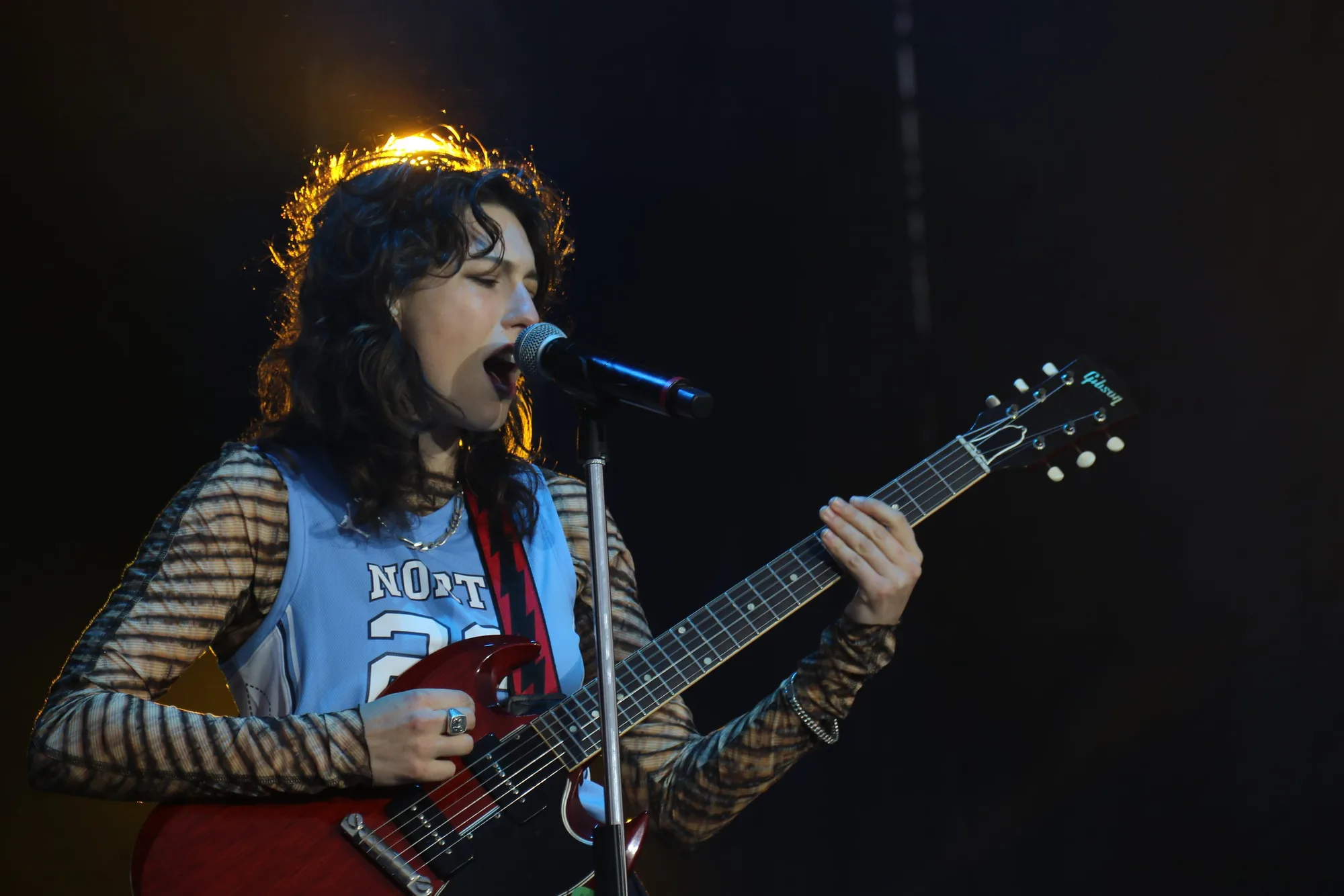 Concert photo of a singer playing guitar on stage