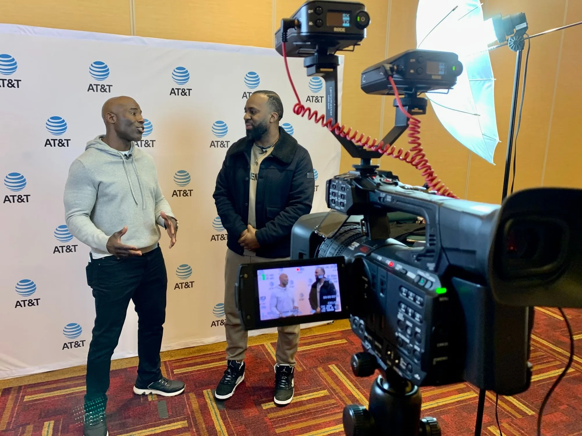 On-camera interview being filmed in front of an event backdrop