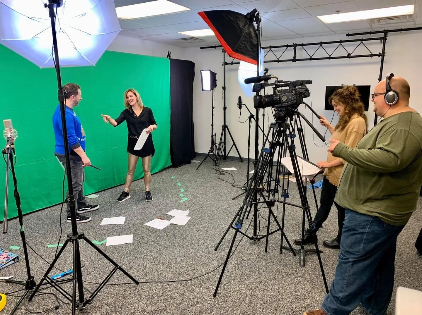 Crew filming a presenter in a green screen studio