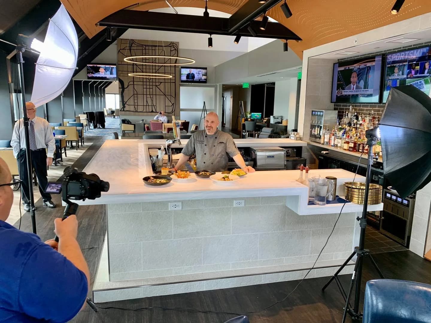Videographer filming a cooking segment in a studio kitchen