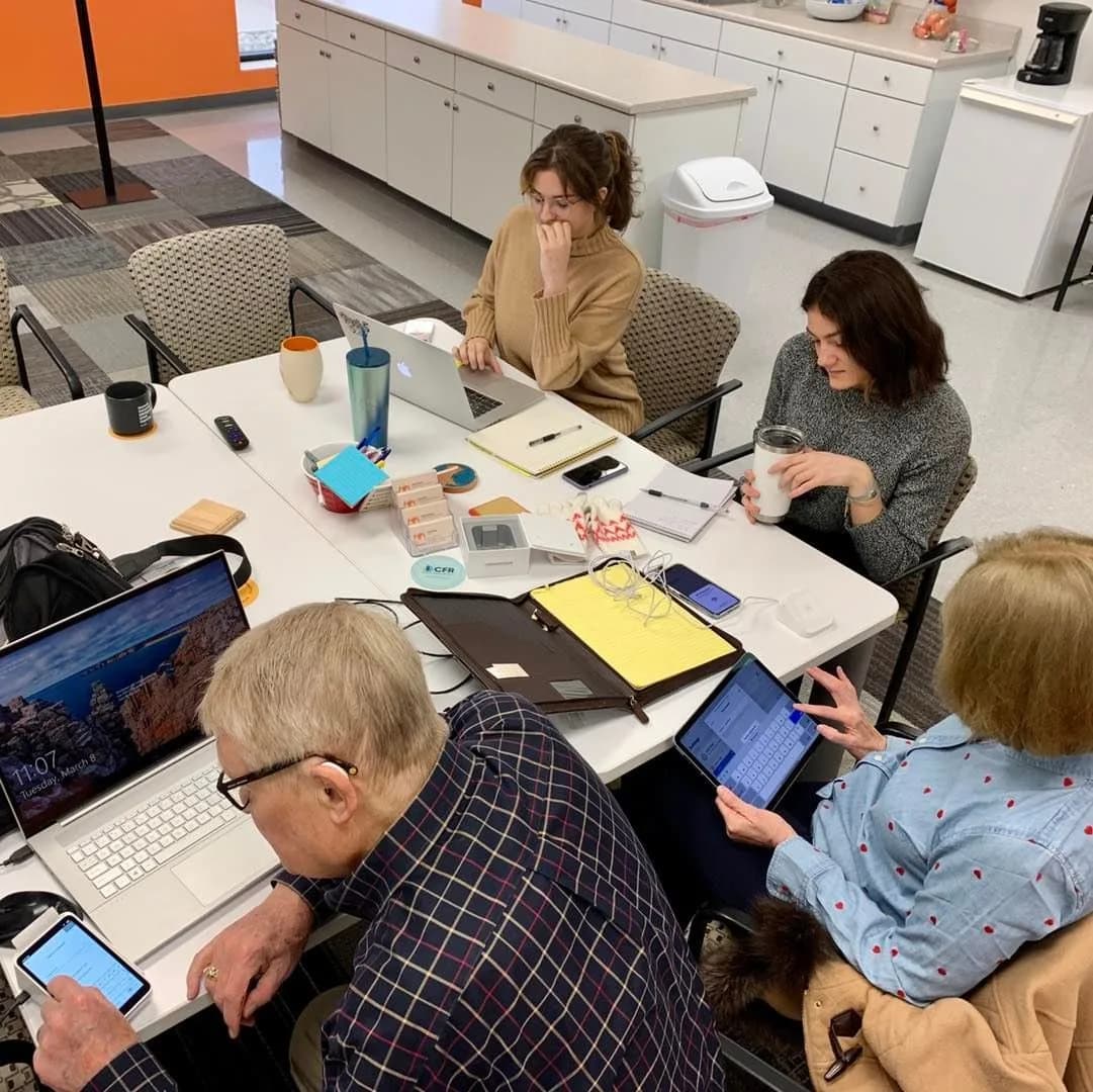 Team members working around a table with laptops and notes