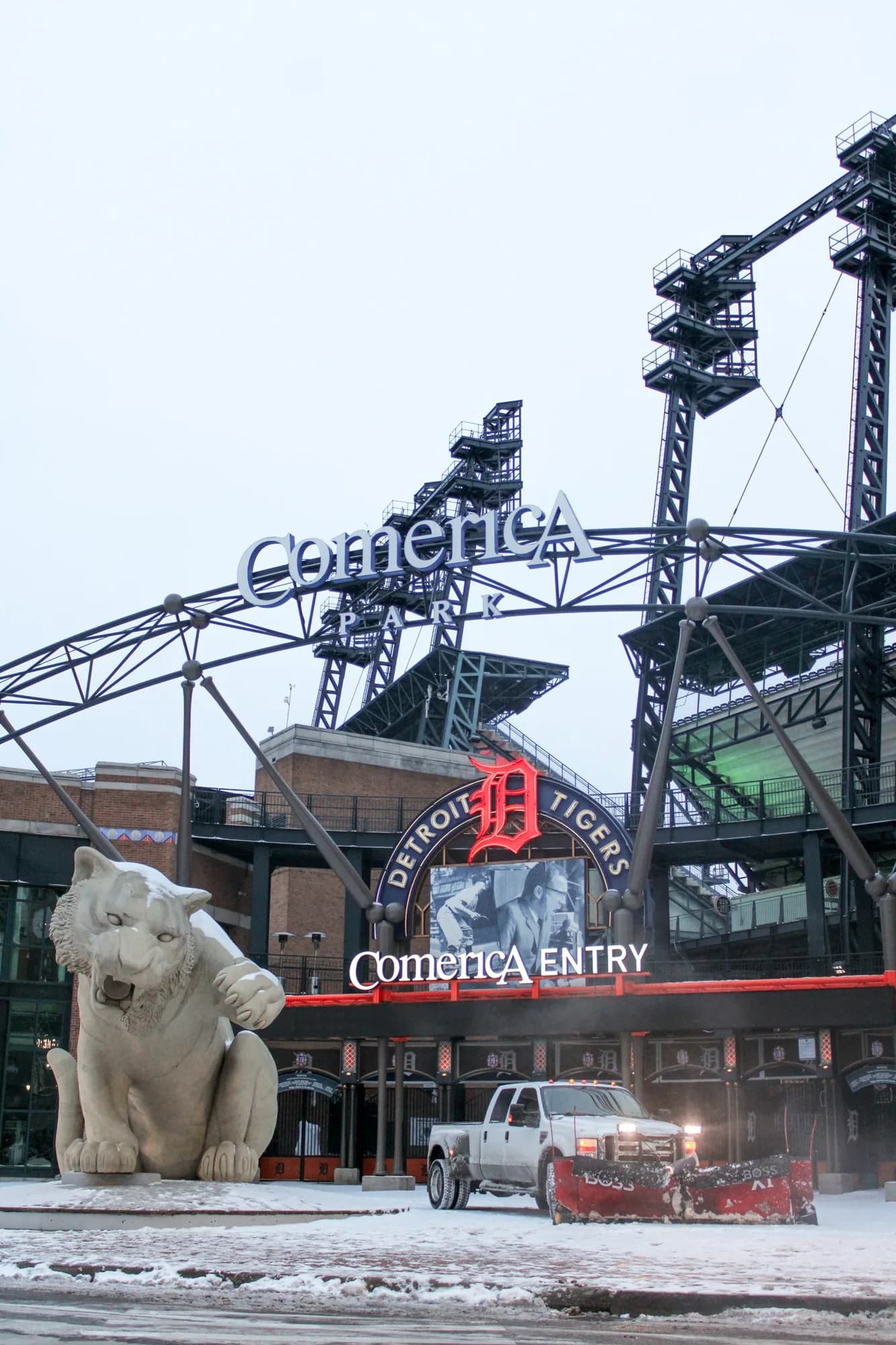 Pickup with a red plow outside Comerica Park in downtown Detroit during snowfall