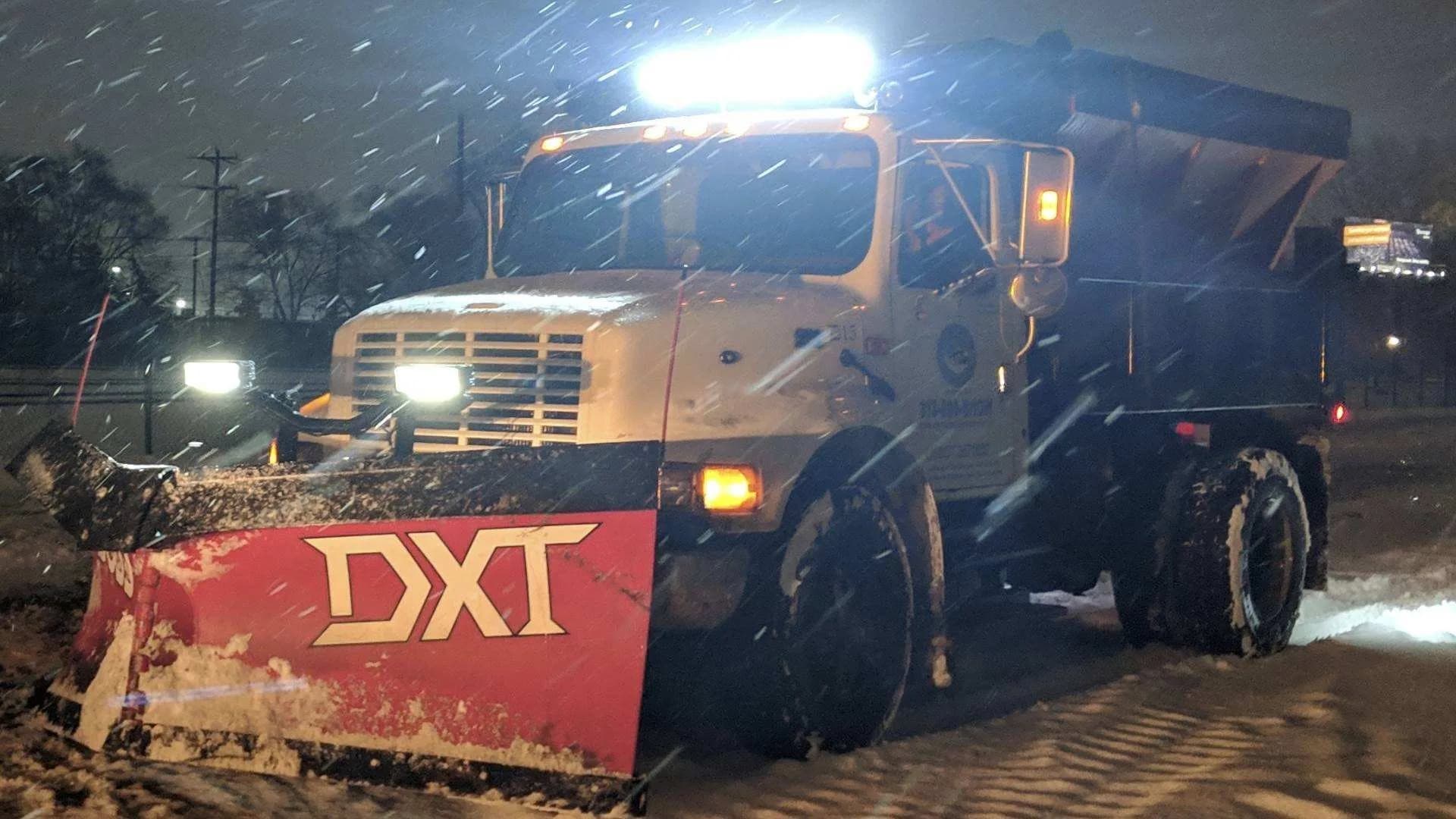 Dump truck with a red DXT plow blade at night