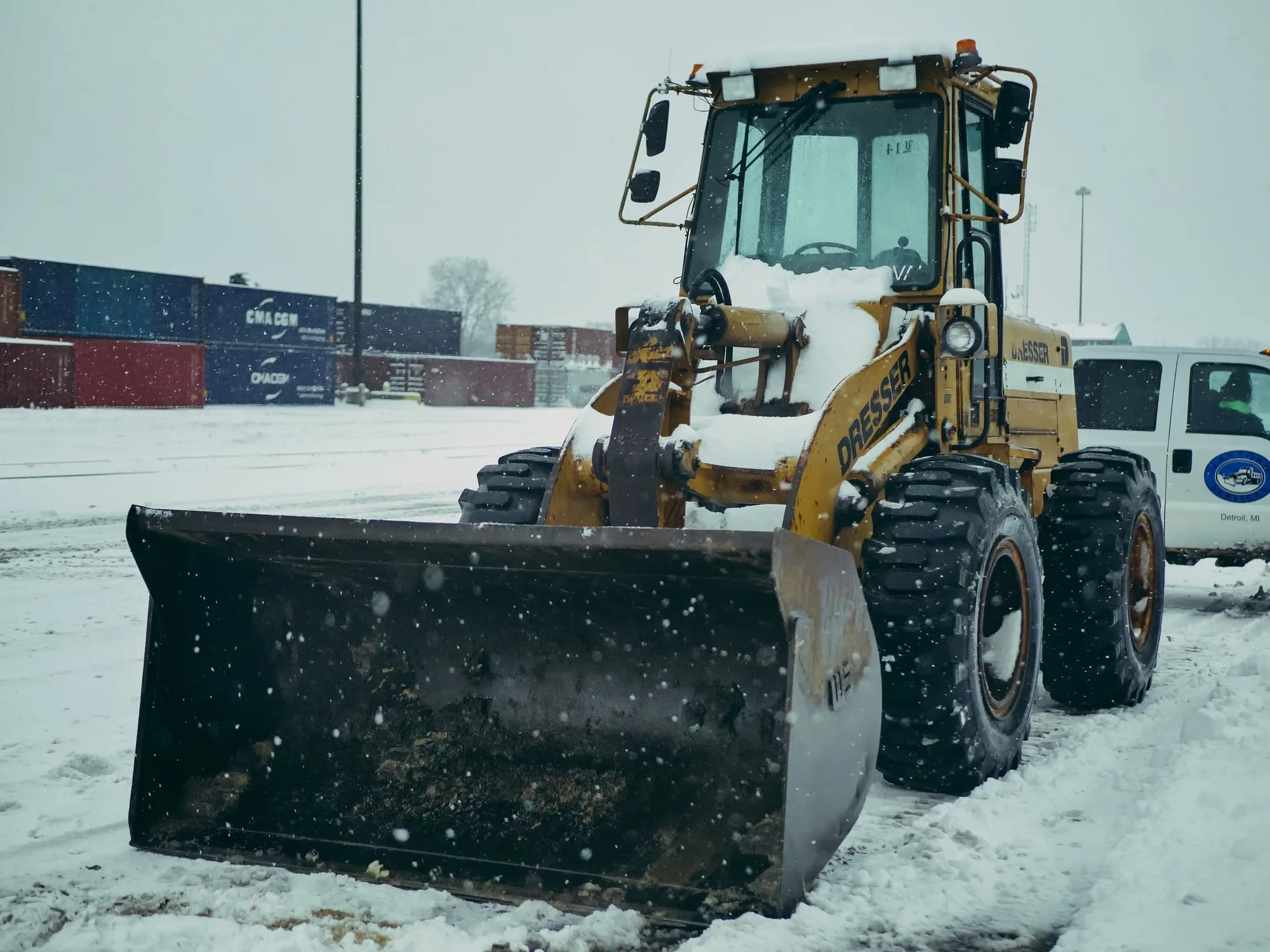 Wheel loader fitted with a snow pusher box on a snow-covered lot