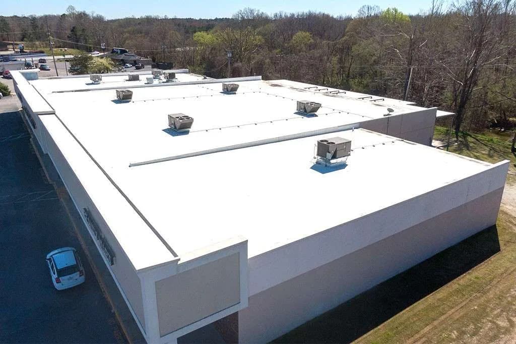 Aerial view of a commercial building with a white flat roof