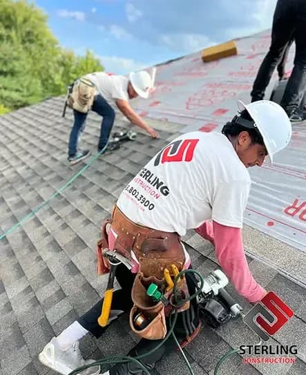 Sterling roofer nailing down architectural shingles