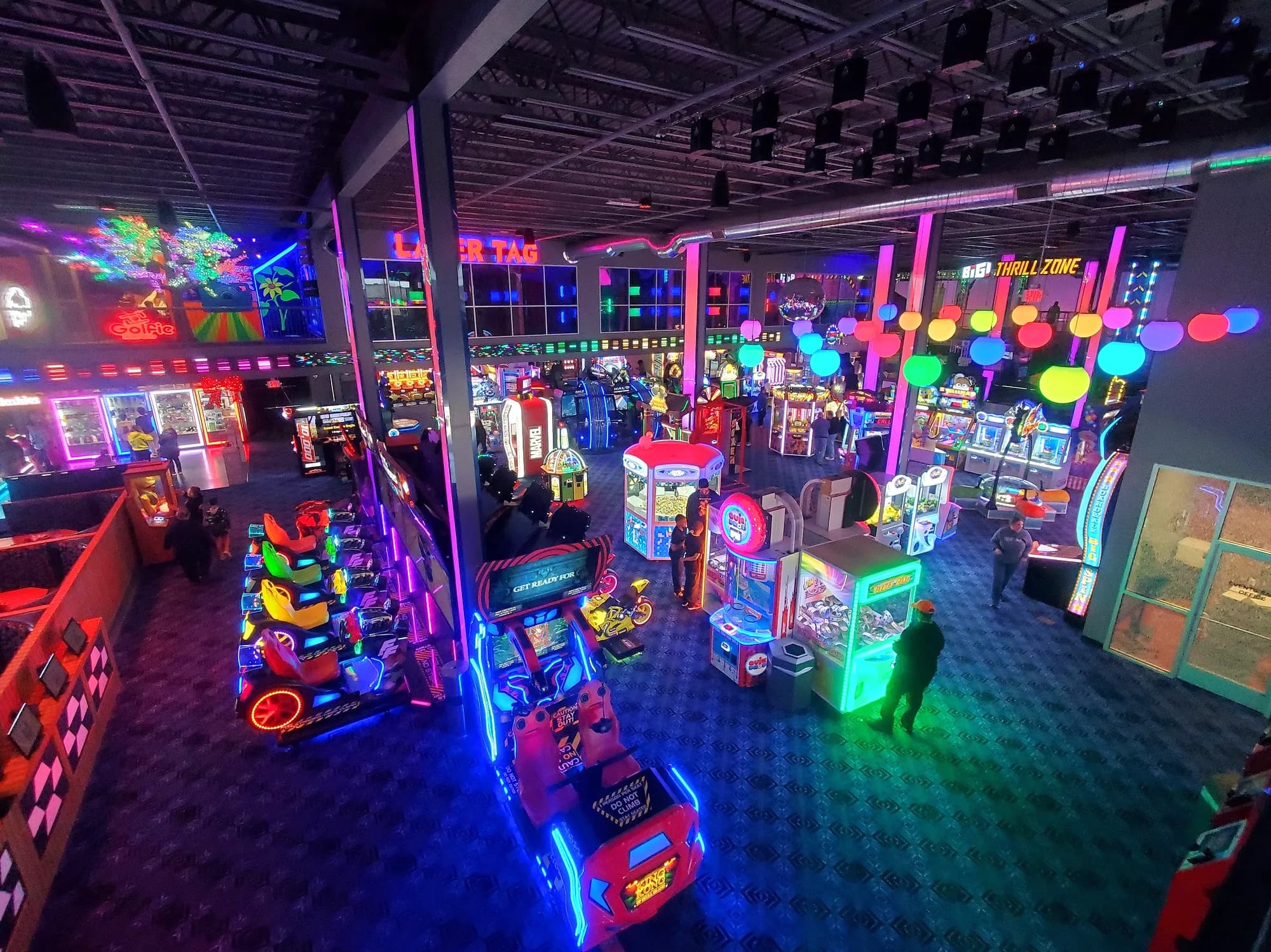 Arcade floor with rows of lit game machines