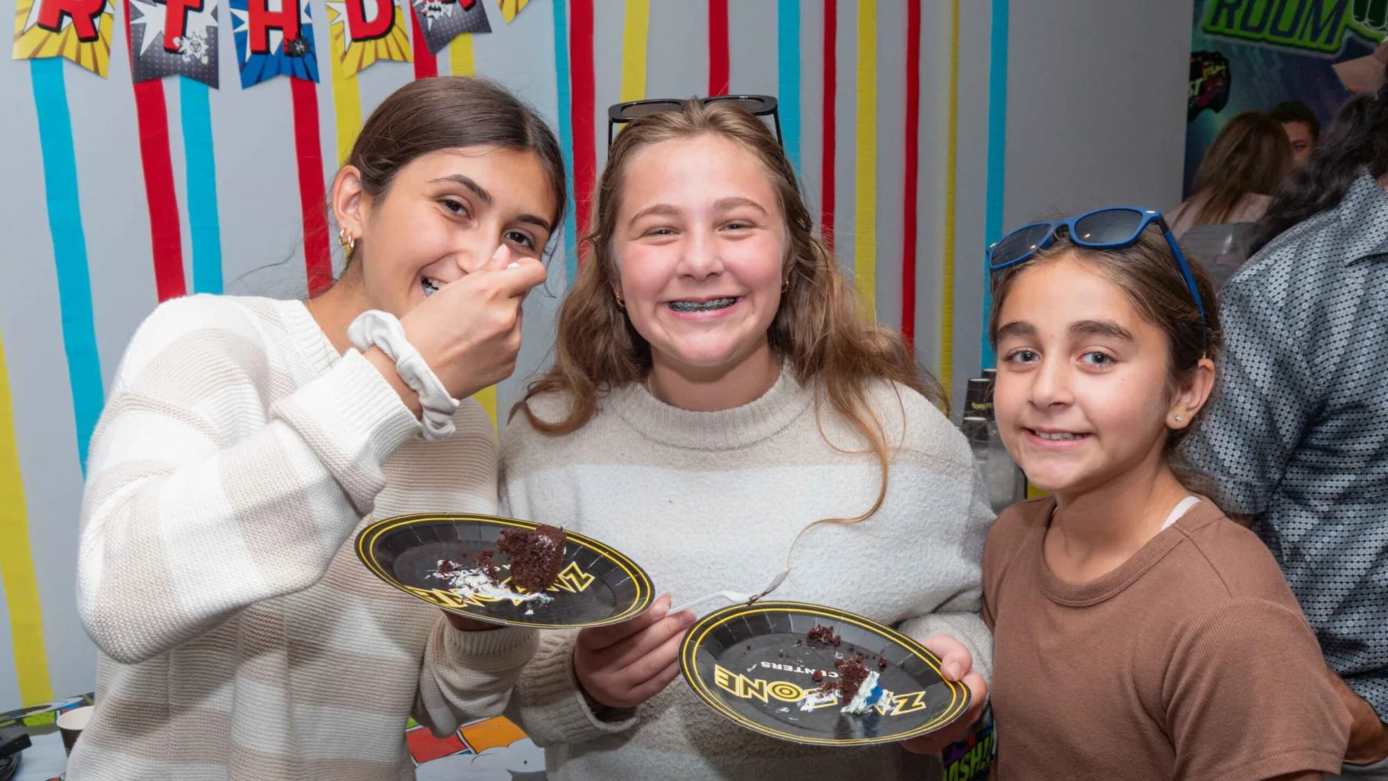Girls laughing at a birthday party with plates of food