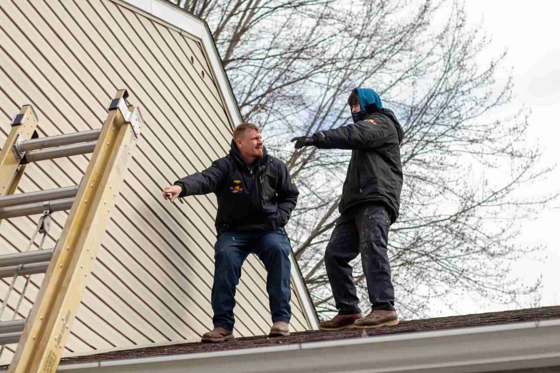 Two Koz technicians working on a house roof