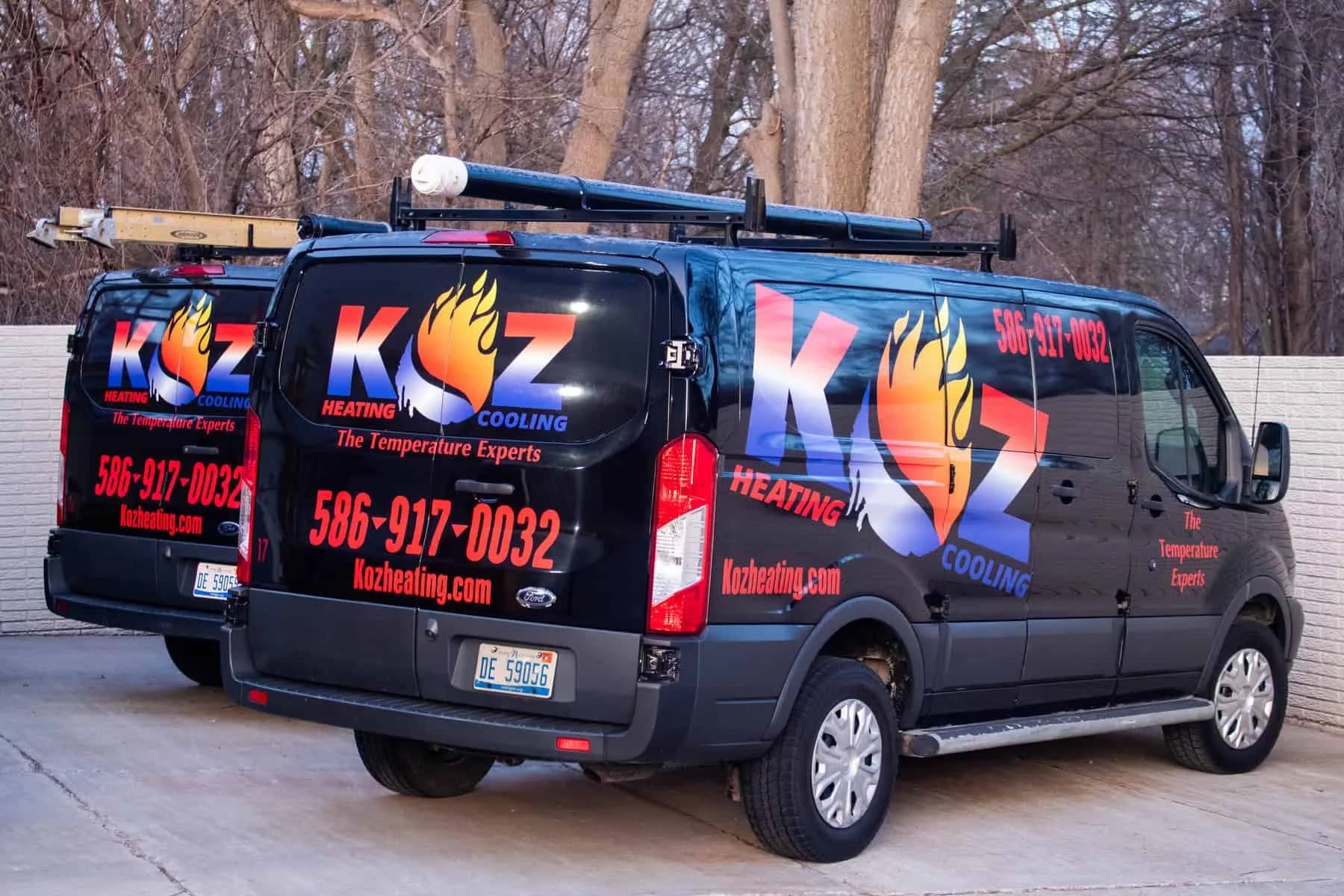 Two Koz service vans parked side by side