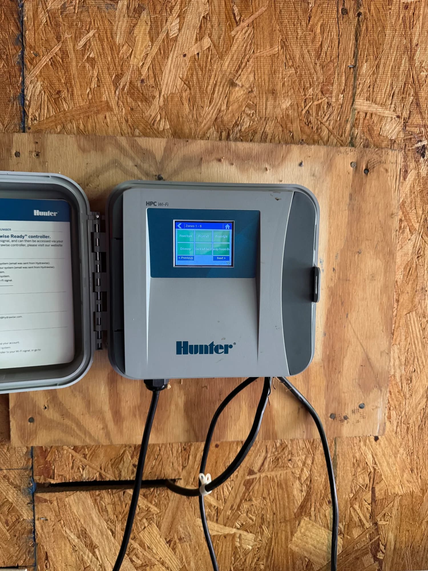 Hunter smart sprinkler controller mounted on a plywood wall