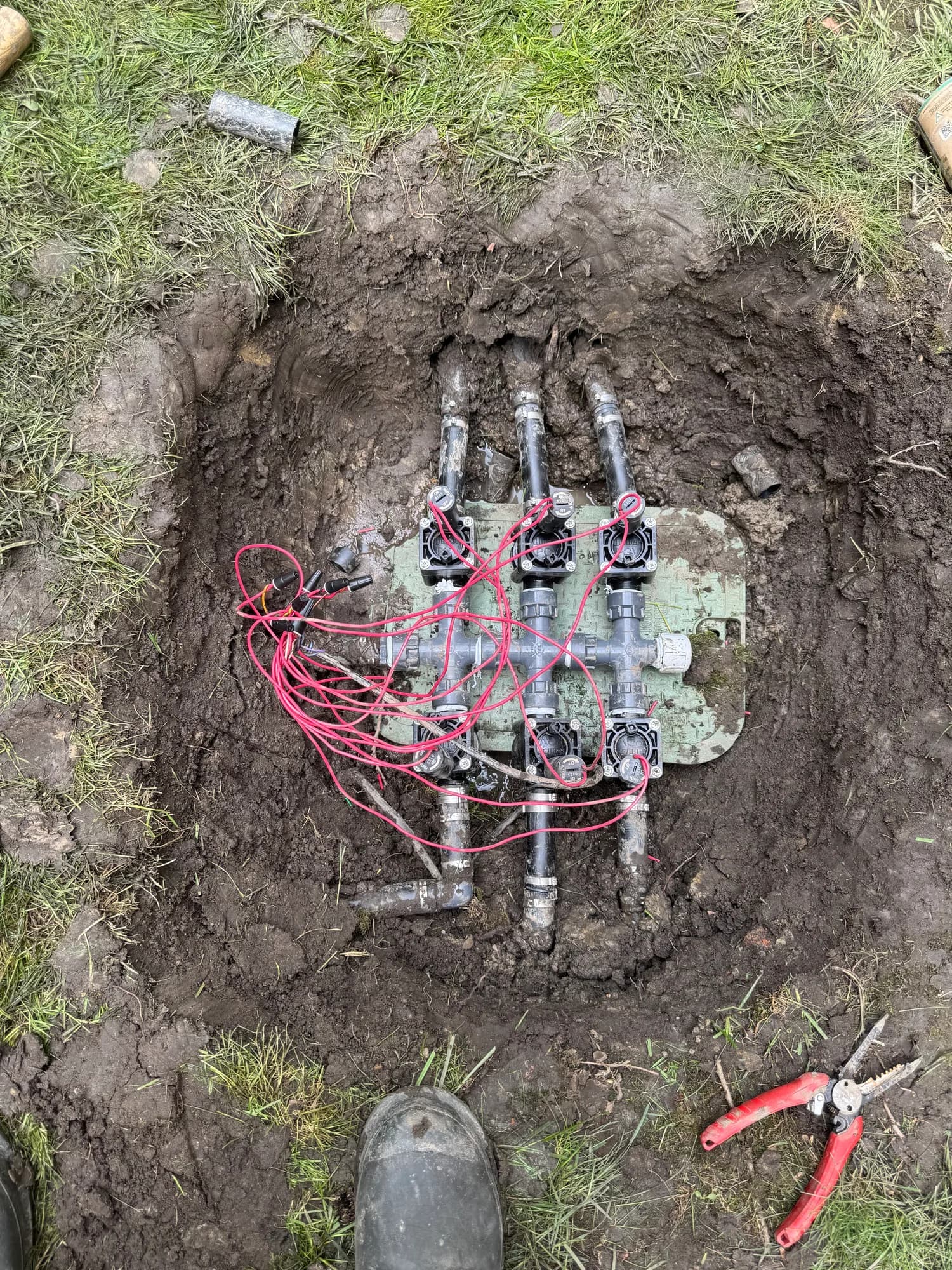 New sprinkler valve manifold with fresh wiring in an excavated valve box