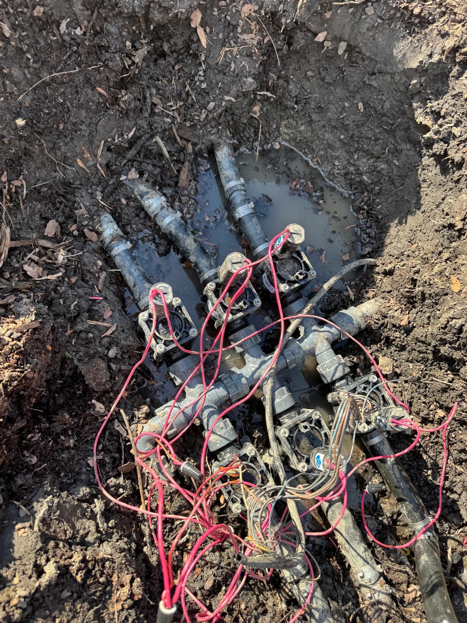 Crowded old valve manifold with tangled wiring uncovered for repair
