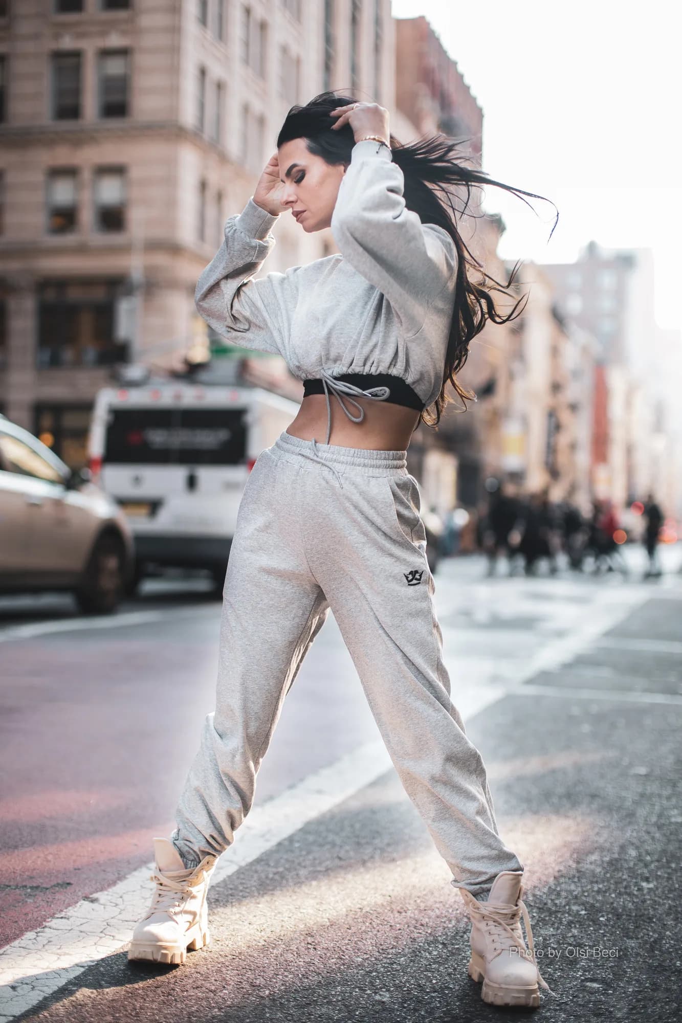 Woman in a gray cropped hoodie and joggers set on a city street
