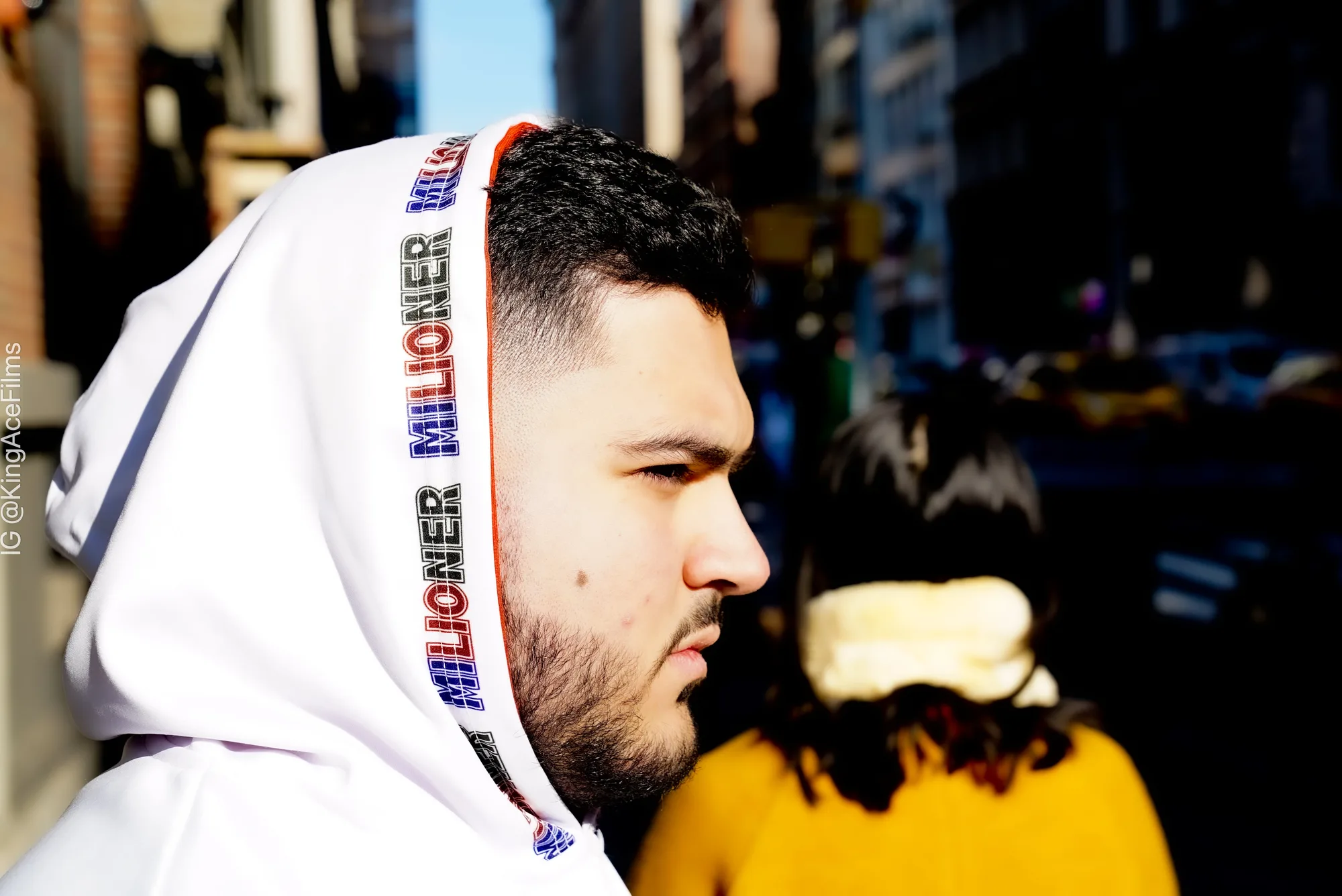 Close-up of a white hoodie with Milioner print on the hood trim