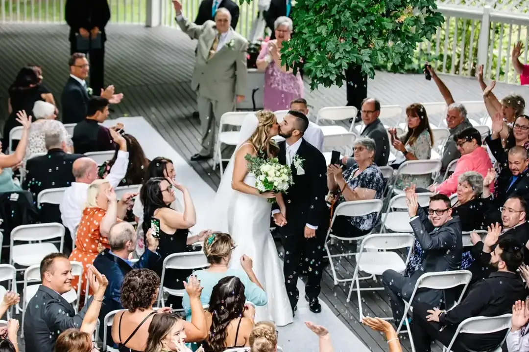 Guests cheering as newlyweds walk back down the aisle