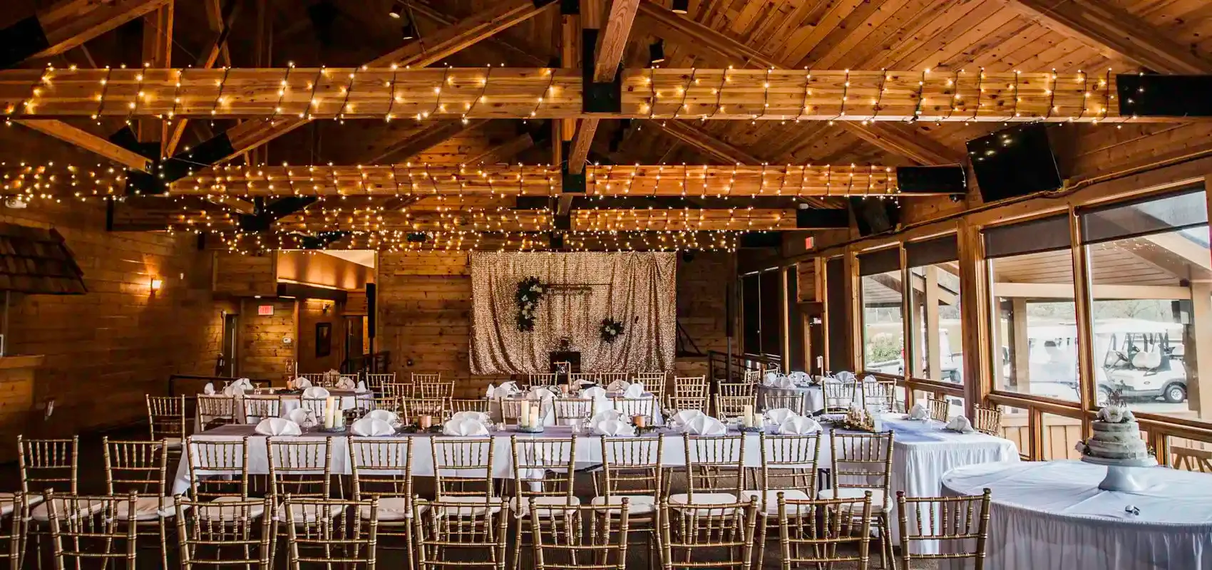 Banquet hall with long tables beneath a wooden ceiling