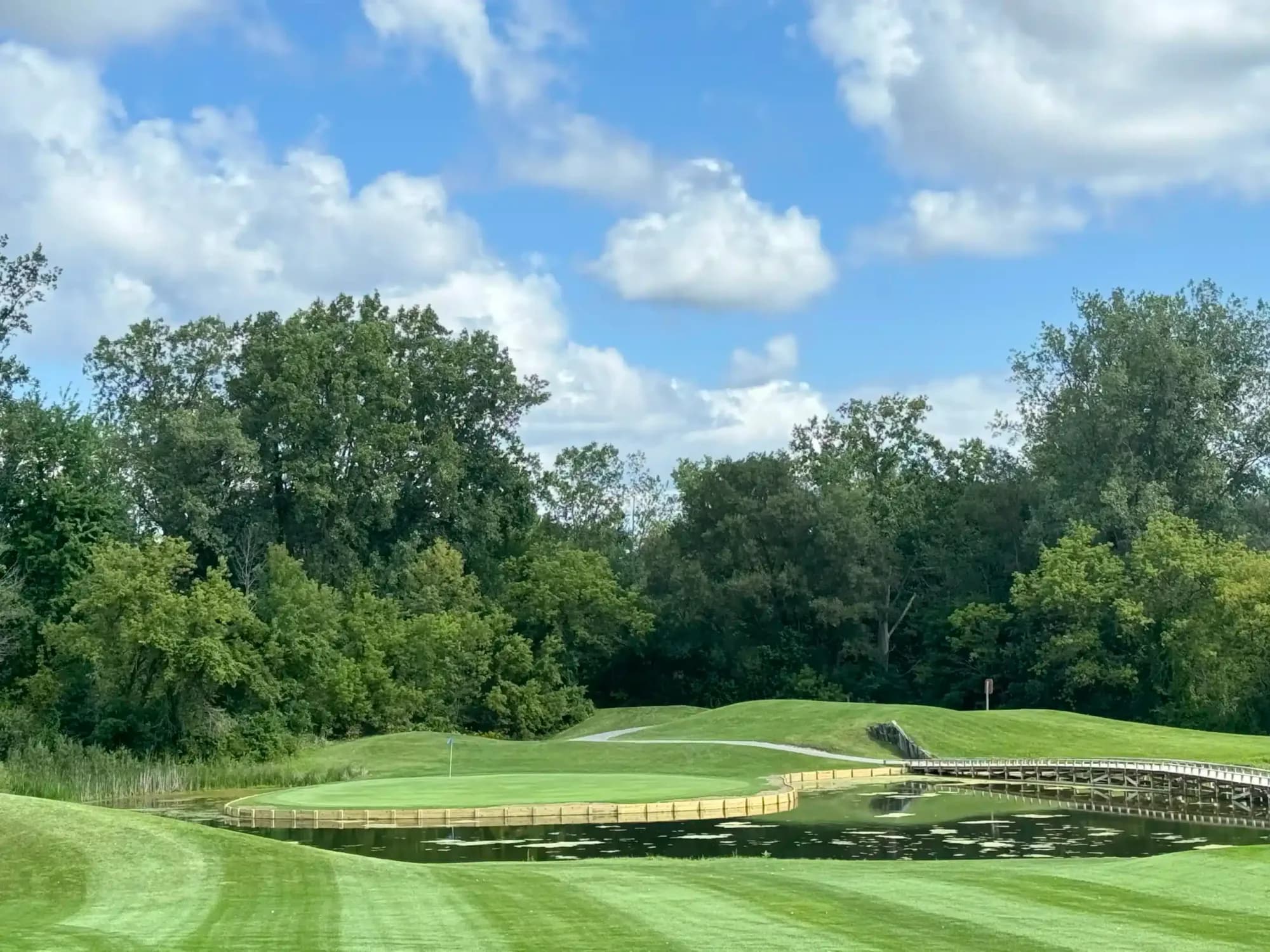 Peninsula green edged by a wooden boardwalk on the Myth course