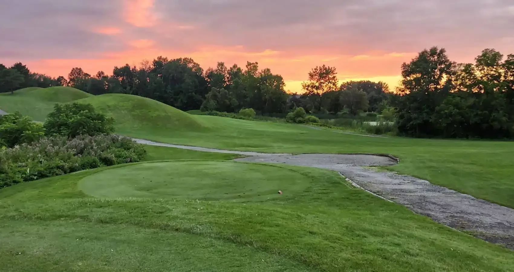Rolling fairway and cart path at sunset
