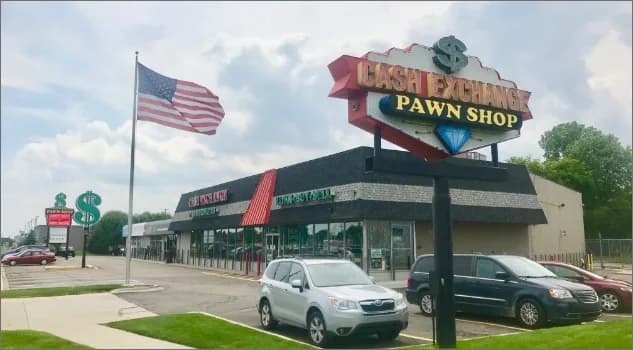 Cash Exchange Pawn Shop pole sign and building with parked cars out front