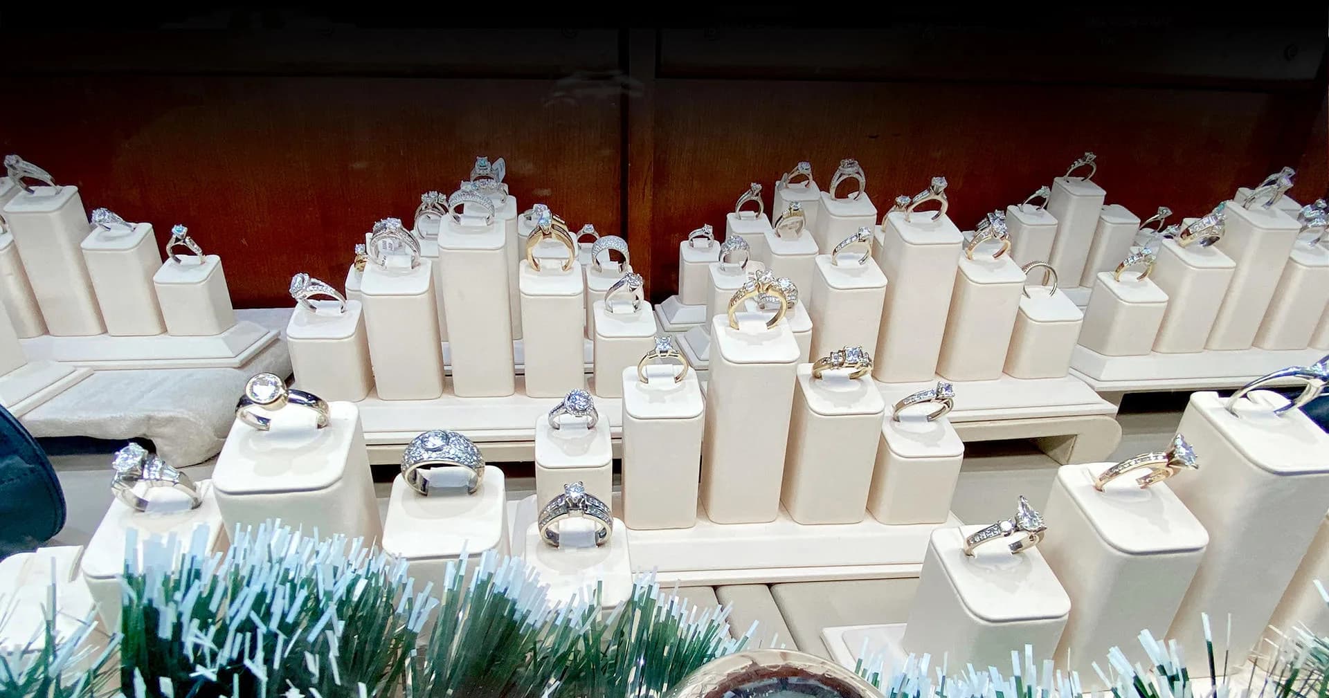Rings on white display stands in a jewelry case