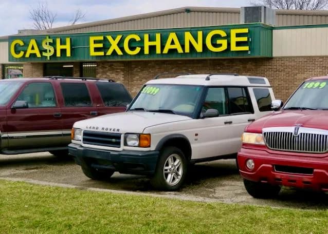 Used SUVs parked for sale in front of a Cash Exchange building