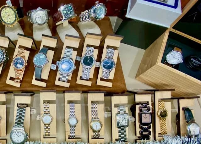 Wristwatches displayed on stands in a glass case